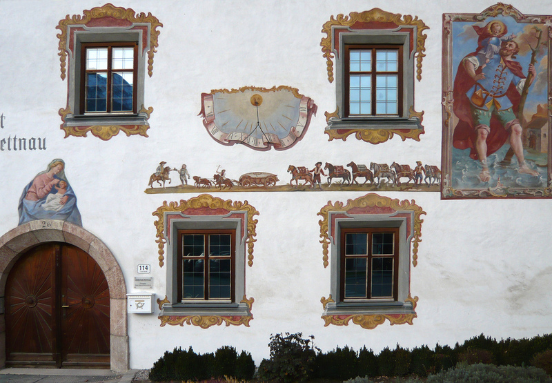 Fassadenmalerei mit Sonnenuhr, Heiligendarstellungen und Fuhrmannszug